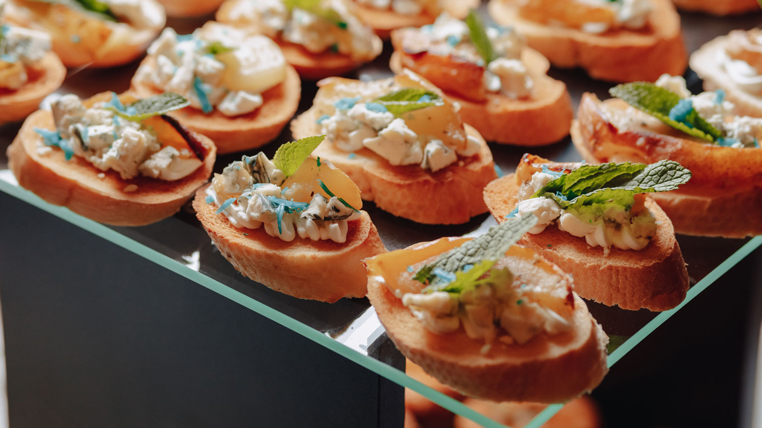 Esposizione di antipasti in un elegante display di vetro, con una varietà di finger food invitanti