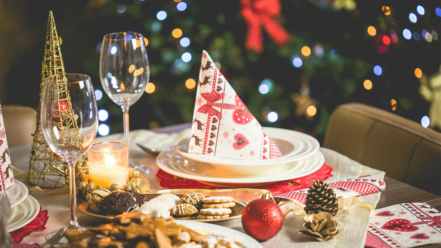 Tavola imbandita con decorazioni natalizie e piatti per una cena aziendale di Natale